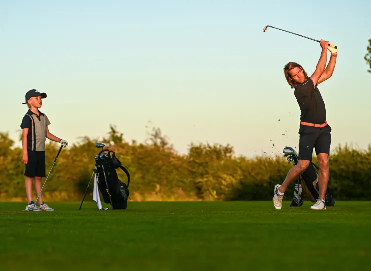 Taking a golf swing playing golf on Staining Lodge Golf Course
